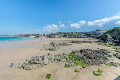 a person standing on a beach with rocks at 3 Bed in Newquay oc-o32259 in Newquay
