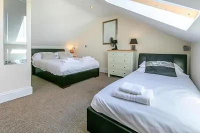 a bedroom with two beds and a mirror at 3 Bed in Newquay oc-o32259 in Newquay