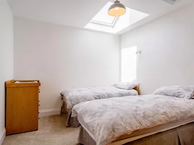 a bedroom with two twin beds and a skylight at On The Beach in Downderry