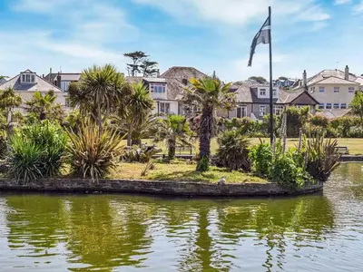a house with a flag in the middle of a body of water at Kerensa in St. Agnes