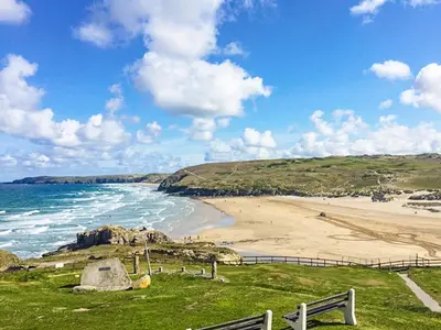 a view of a beach with a fence and the ocean at Kerensa in St. Agnes