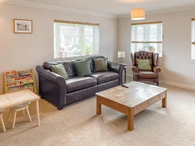 a living room with a leather couch and a coffee table at Kerensa in St. Agnes
