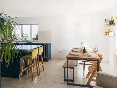 a kitchen with a table and a dining room at Kerensa in St. Agnes