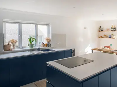 a kitchen with blue cabinets and a sink at Kerensa in St. Agnes