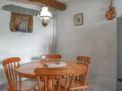 a dining room table with chairs and a light at Stables - Uk50372 in Camelford