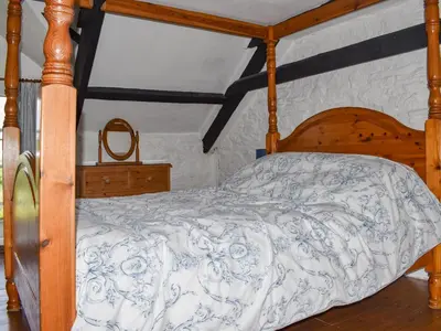 a bedroom with a wooden bed with a wooden frame at Stables - Uk50372 in Camelford