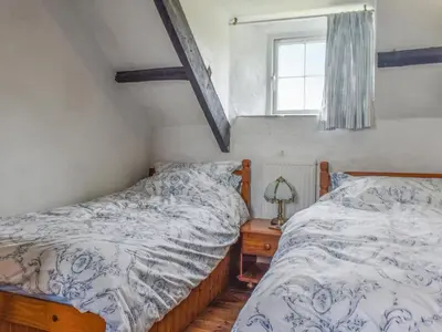 two twin beds in a bedroom with a window at Stables - Uk50372 in Camelford