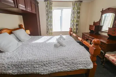 a bedroom with a bed with a teddy bear on it at 28 Guildford Road in Hayle