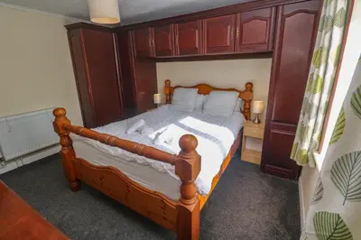 a bedroom with a bed with a wooden headboard at 28 Guildford Road in Hayle