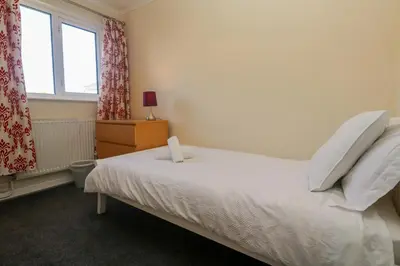 a bedroom with a white bed and a window at 28 Guildford Road in Hayle