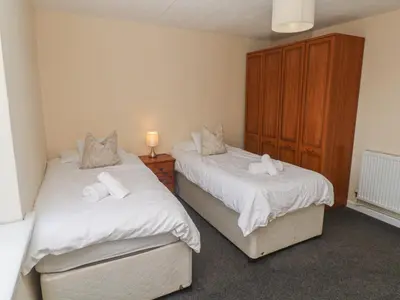 a bedroom with two beds with white sheets at 28 Guildford Road in Hayle