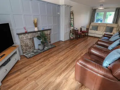 a living room with a leather couch and a fireplace at 28 Guildford Road in Hayle