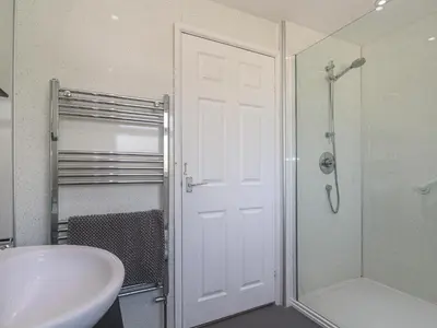 a bathroom with a sink and a shower and a white door at 28 Guildford Road in Hayle