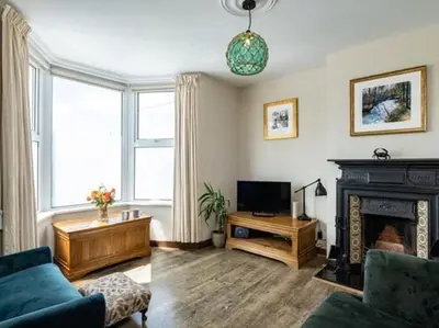 a living room with a couch and a fireplace at VARLEY VIEW Fishermans cottage with stunning views in Port Isaac