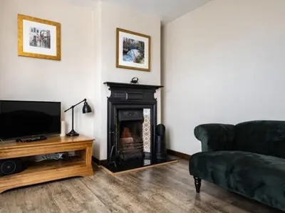 a living room with a couch and a fireplace at VARLEY VIEW Fishermans cottage with stunning views in Port Isaac