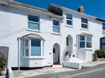 a white house with white windows on a street at VARLEY VIEW Fishermans cottage with stunning views in Port Isaac