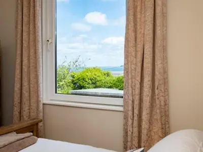 a bedroom with a window with a view at VARLEY VIEW Fishermans cottage with stunning views in Port Isaac