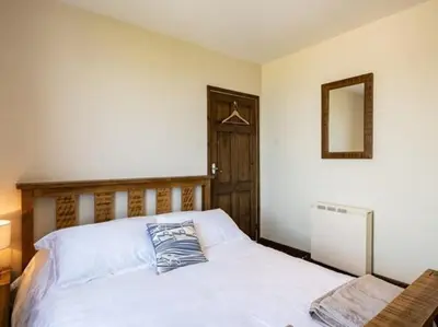 a bedroom with a bed with a pillow on it at VARLEY VIEW Fishermans cottage with stunning views in Port Isaac