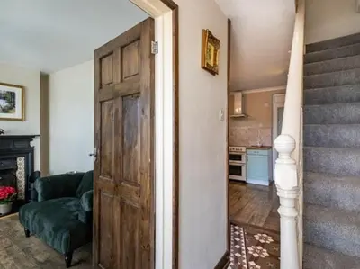 a living room with a staircase and a door at VARLEY VIEW Fishermans cottage with stunning views in Port Isaac