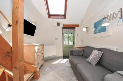a living room with a couch and a tv at Little Coombe in Liskeard