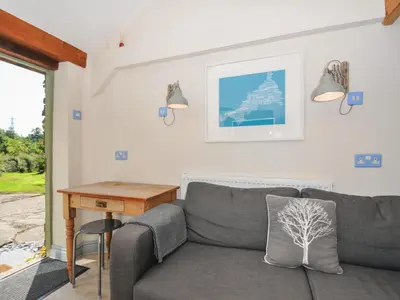 a living room with a couch and a table at Little Coombe in Liskeard