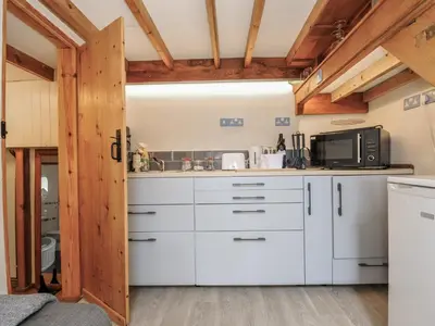 a kitchen with white cabinets and a microwave at Little Coombe in Liskeard