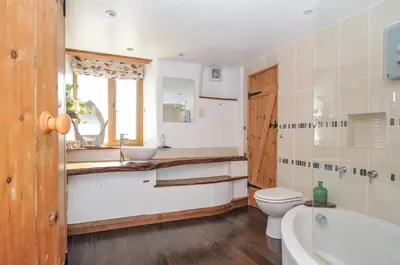 a bathroom with a sink and a toilet and a tub at Little Coombe in Liskeard