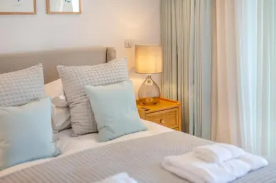 a bedroom with a bed with blue and white pillows at 3 Bed in Padstow oc-w28313 in St Merryn