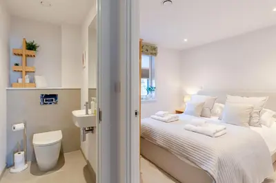 a white bedroom with a bed and a sink at 3 Bed in Padstow oc-w28313 in St Merryn