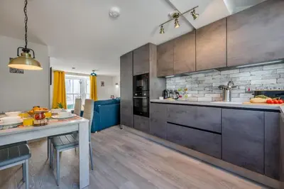 a kitchen with wooden cabinets and a table in it at 2 Bed in St. Ives oc-e28156 in St Ives