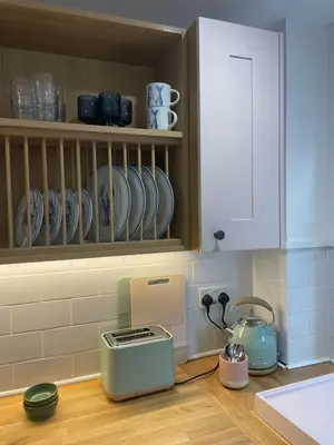 a kitchen with a toaster and plates on a counter at Beachy Maisonette- 2 Min walk to Porth Beach in Newquay