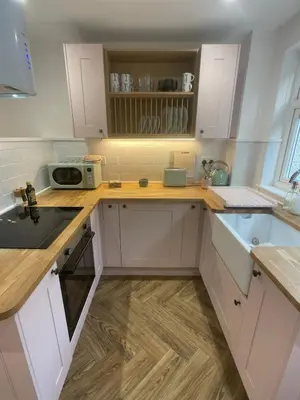 a kitchen with white cabinets and a microwave at Beachy Maisonette- 2 Min walk to Porth Beach in Newquay