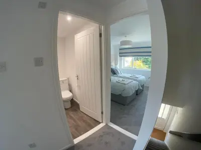 a bedroom with a bed and a toilet and a window at Beachy Maisonette- 2 Min walk to Porth Beach in Newquay