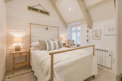 a bedroom with a bed and a sign on the wall at Cor anglais in Port Isaac