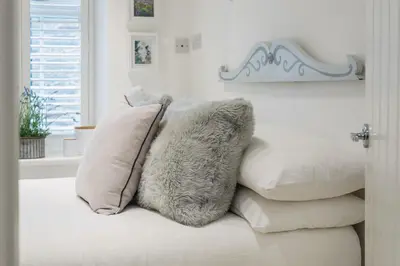 a pile of pillows sitting on top of a bed at Cor anglais in Port Isaac