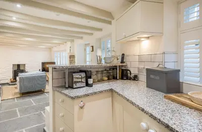 a kitchen with white cabinets and a counter top at Cor anglais in Port Isaac