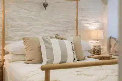 a bedroom with a bed with white pillows at Cor anglais in Port Isaac