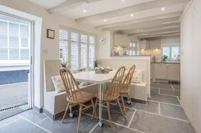 a kitchen with a table and four chairs at Cor anglais in Port Isaac
