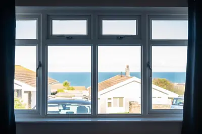 an open window with a view of a car at Silvershell House in Port Isaac