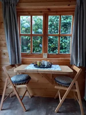 a wooden table and chairs in a room with a window at The Nook in St Ives