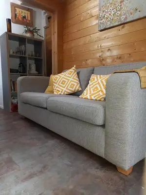 a gray couch with pillows on it in a room at The Nook in St Ives
