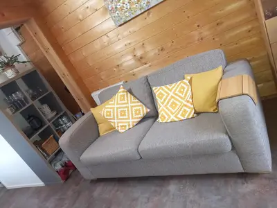a gray couch with yellow pillows in a living room at The Nook in St Ives