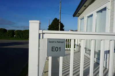 a sign on a white fence in front of a house at Sarahs Retreat in Par