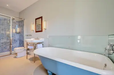 a bathroom with a tub and a toilet and a sink at 8 Bed in Tresillian oc-t32986 in Newlyn East