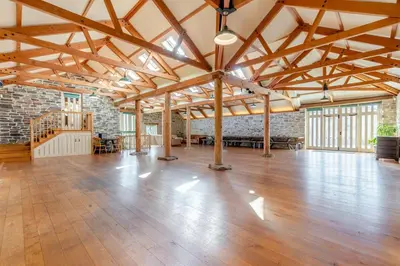 a large room with a wooden floor and a brick wall at 8 Bed in Tresillian oc-t32986 in Newlyn East