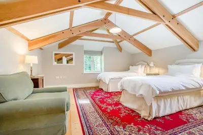 two beds in a room with a couch and a rug at 6 Bed in Tresillian oc-t32987 in Newlyn East