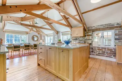 an open kitchen with wooden cabinets and a brick wall at 6 Bed in Tresillian oc-t32987 in Newlyn East