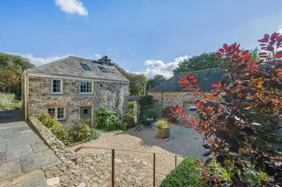 an external view of a stone house with a garden at 1 Bed in Tresillian oc-t32988 in Newlyn East