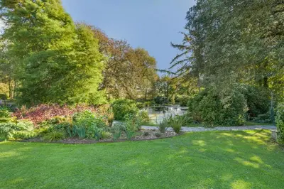 a garden with green grass and trees and a pond at 1 Bed in Tresillian oc-t32988 in Newlyn East