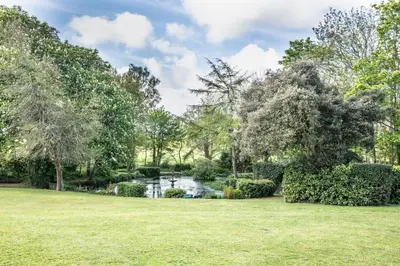a lush green yard with a pond and trees at 1 Bed in Tresillian oc-t32988 in Newlyn East